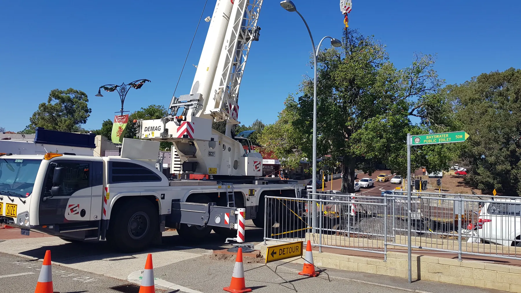 Mobile crane set up on a town civil works site with traffic control