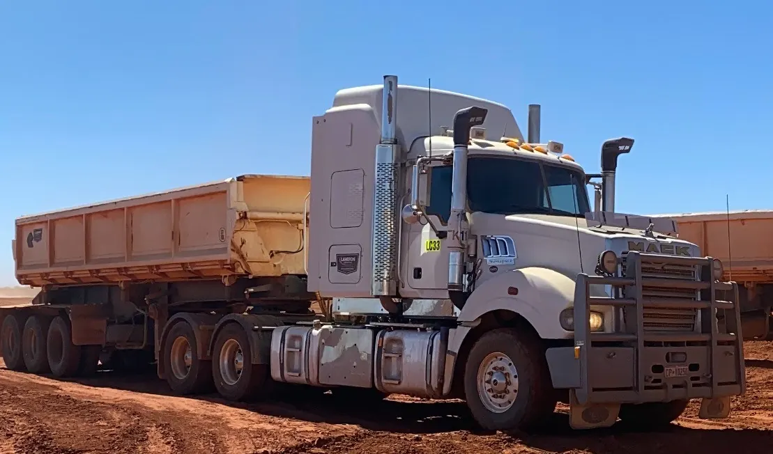 Road train parked on a red dirt site